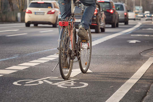 Ein Fahrrad ist von hinten auf einem Fahrradweg neben einer Straße zu sehen Canetti via Getty Images